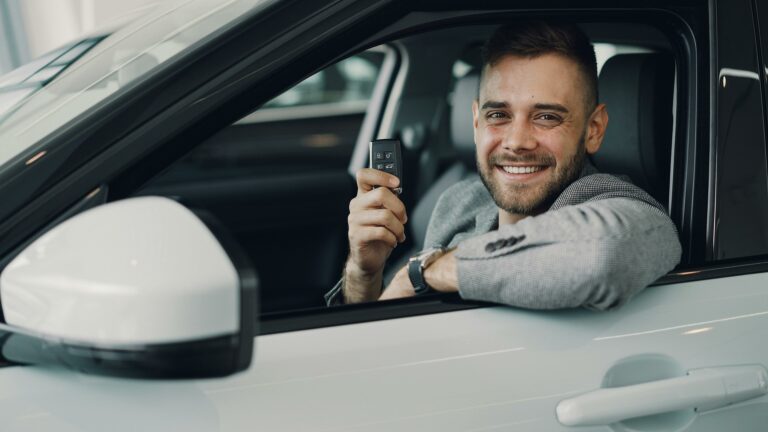 Przedstawiciele firmy omawiają umowę leasingu samochodu w salonie dealerskim.